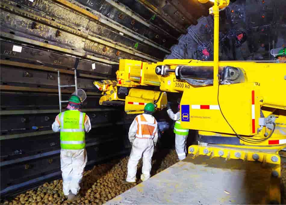Personal técnico junto a maquinaria de mantenimiento de molino